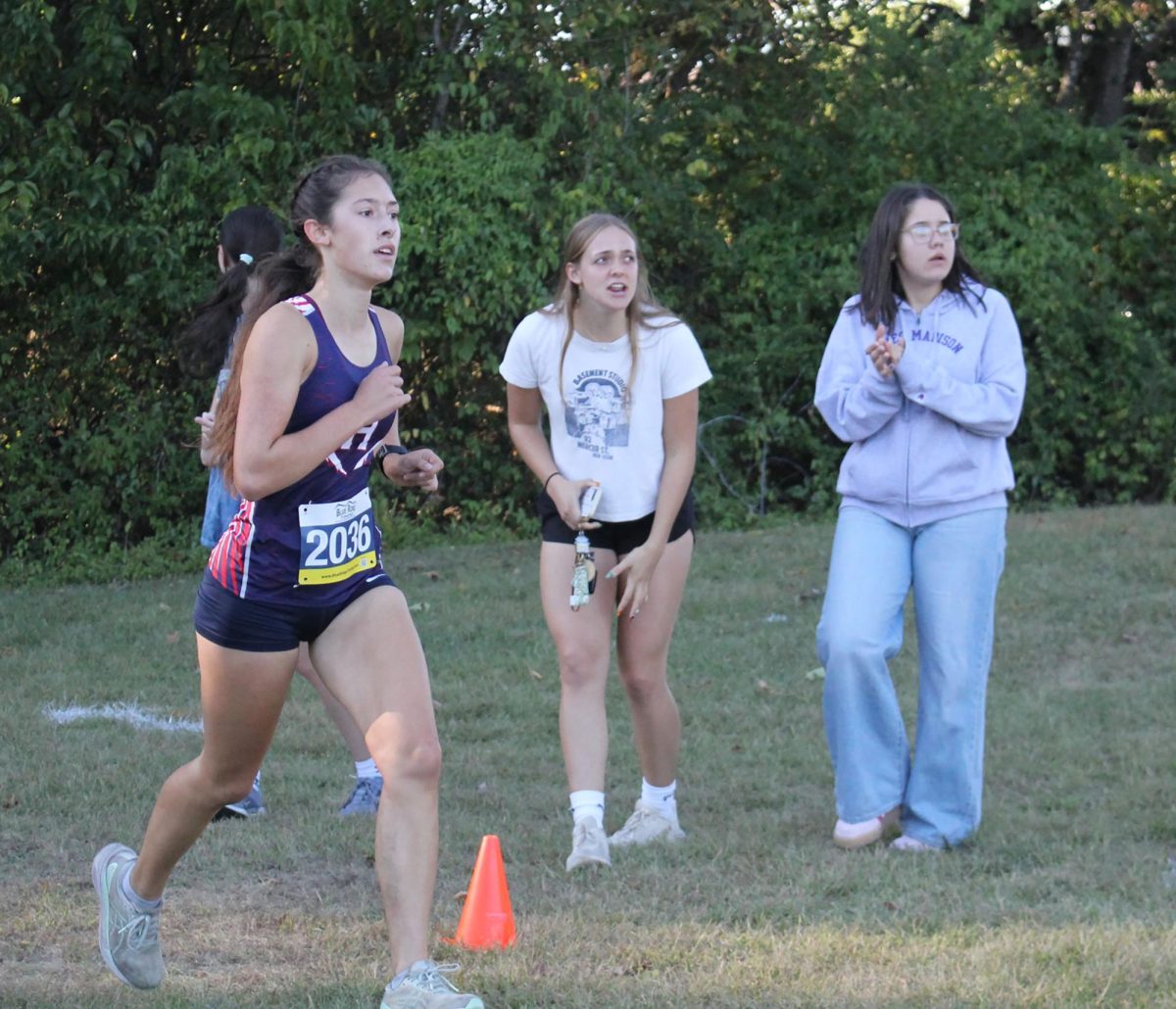 Senior Sophie Kauffman runs while fans cheer her on.