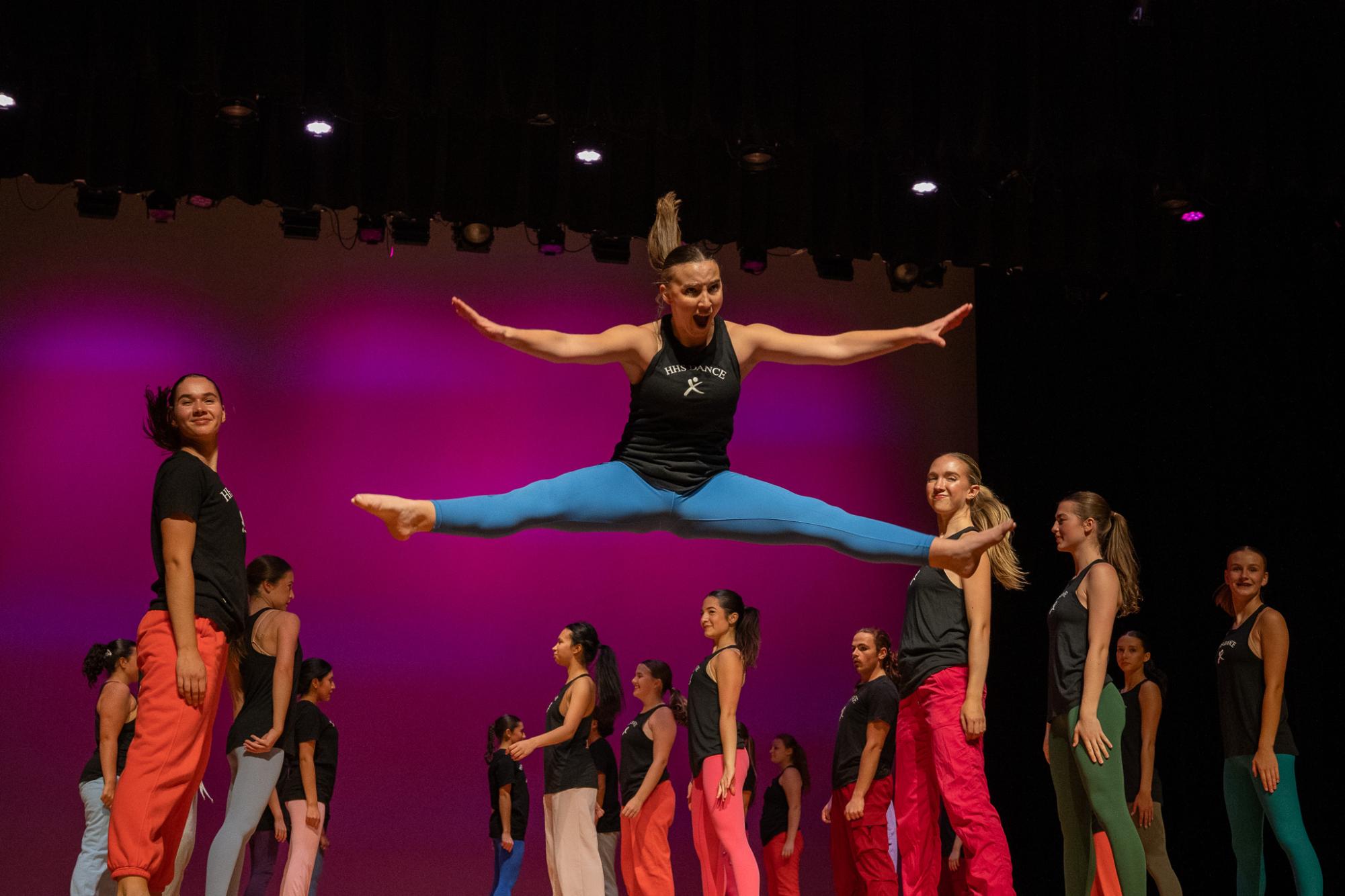 Senior Annie Snow from Harrisonburg High School jumps into the air for her part in the performance of "Party Rock." Snow's split-jump is a part of the performance which required extra practice. "To perform the split-jump, I had to improve my flexibility and I had to work on my squats, so that I would be able to get the momentum I need to get up in the air," Snow said. For Snow, this part of the performance is unlike other jumps. "The split-jump is one of the few tricks in dance that I can do really well. It's something that I have to prepare for during the performance, but once I'm off the ground it's just a freeing moment that feels effortless," Snow said.