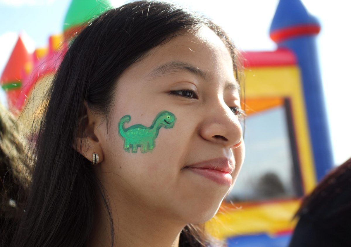 Sophomore Karen Lopez Valasquez shows her face paint by a volunteer.