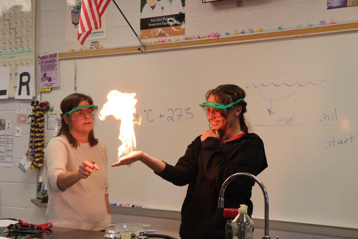 Lucy Hunter demonstrates the propane and flame experiment as the fire rises safely from the chemical reaction. "I was so scared for the part when the flame was on my hand since I thought it was going to hurt which it didn't"- Sophomore Lucy Hunter