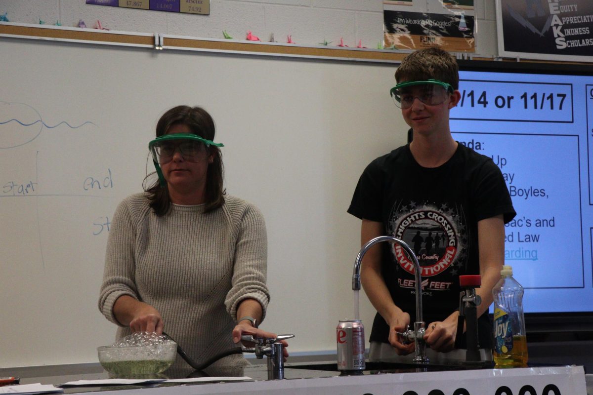 Suzanne Smith getting Noah ready for the experiment involving heat and reactions. "I was super ready for the experiment"-Sophomore Joah Newcomer Miller 