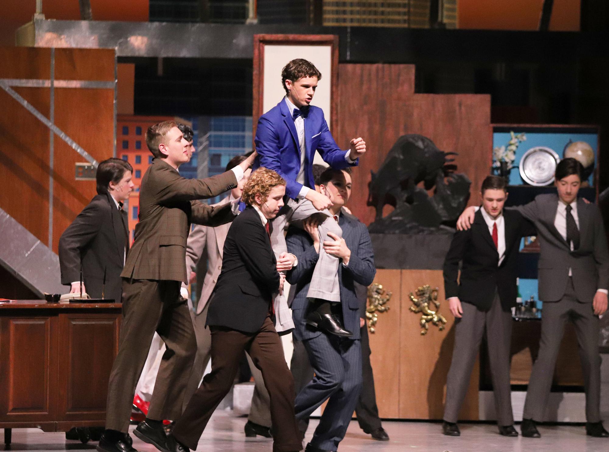 Lead Actor, Billy Perritt is moved across the stage on the shoulders of his classmates.