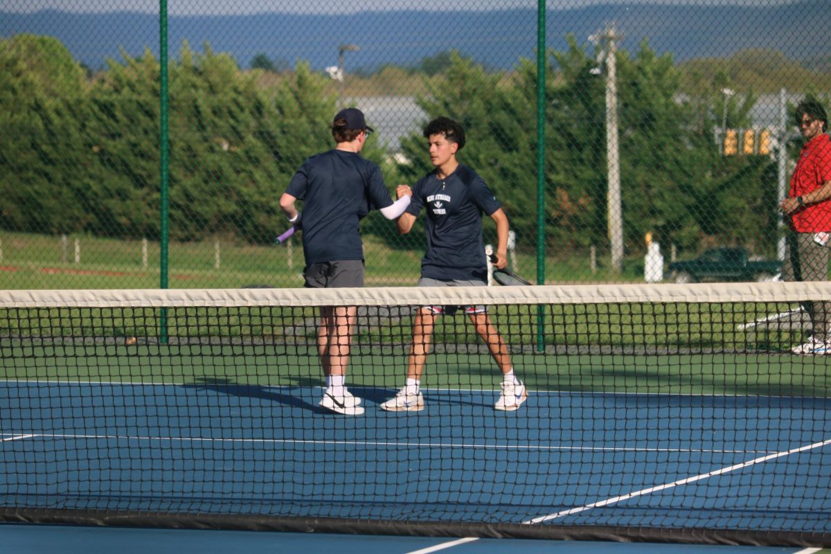Junior Shea Gibson and senior Edwin Martinez high five after a point.