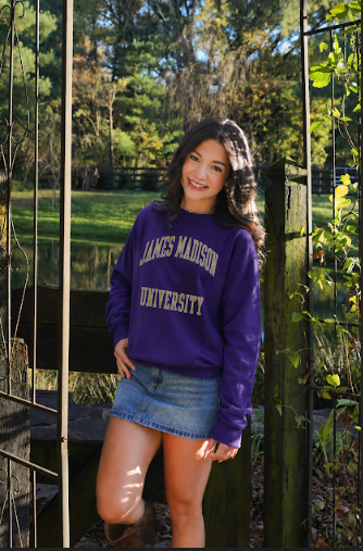 Senior Makayla Suffecool poses for her senior picture with a sweatshirt of her future college, JMU. 