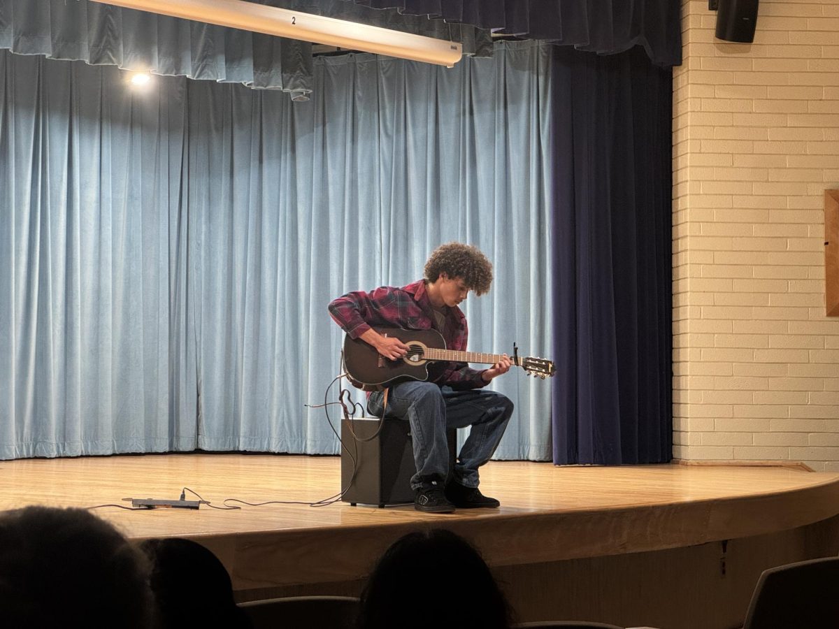 Senior Zion Hunter plays his guitar at the Tri-M recital. He played Children by Robert Miles. "I chose this song because it had clear sections and was manageable for me to learn," Hunter said.