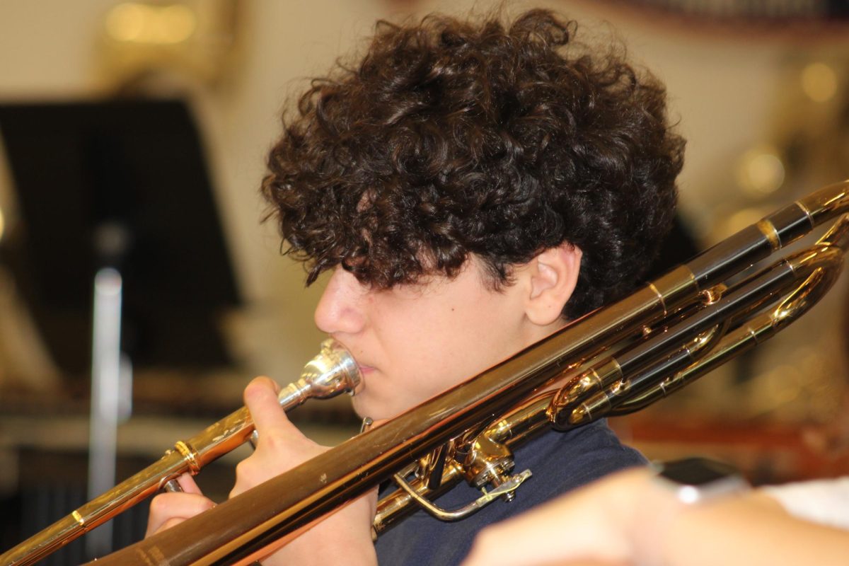 Freshman Julian Nussbaum reads his trombone music.